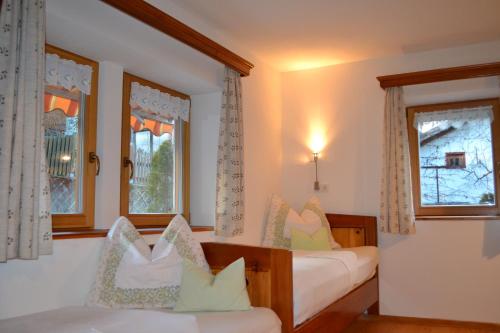 1 dormitorio con 2 camas y 2 ventanas en Ferienwohnung Pramstaller en Valdaora