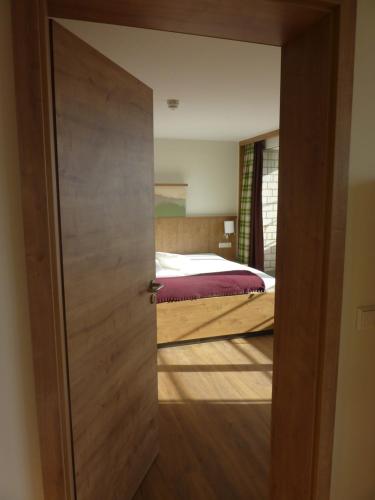 a door leading into a bedroom with a bed at Gasthaus Sonne Neuhäusle in Sankt Märgen
