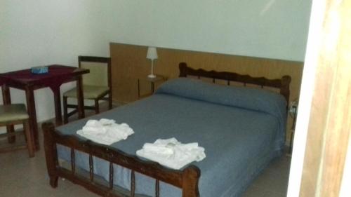 a bedroom with a bed with two towels on it at Posada A Lo De Santys in Villa Independencia