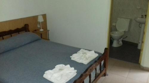 una camera da letto con un letto e due asciugamani di Posada A Lo De Santys a Villa Independencia