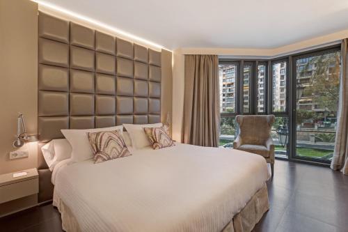 a bedroom with a large bed and a large window at Hotel Palladium in Palma de Mallorca
