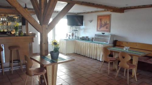 a kitchen with a bar and a table and chairs at Pension Forsthaus Täle in Titisee-Neustadt