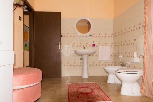 a bathroom with a sink and a toilet and a mirror at Locazione Turistica Girasole in Porto Tolle