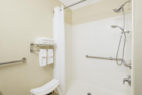 a bathroom with a shower with a toilet and towels at Microtel Inn & Suites by Wyndham in Seneca Falls