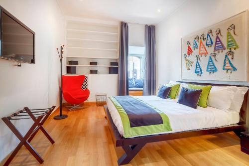 a bedroom with a bed and a red chair at HT N°9 Colosseo in Rome