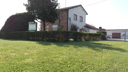 a yard with a house and a hedge at Locazione Turistica Girasole in Porto Tolle