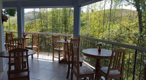 two tables and chairs on a balcony with a view at Pousada D'amoras in Conservatória