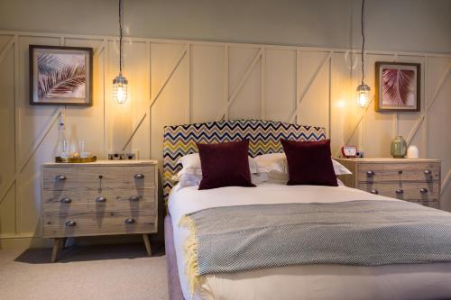 a bedroom with a bed and a dresser and lights at The Chequers Marlow in Marlow
