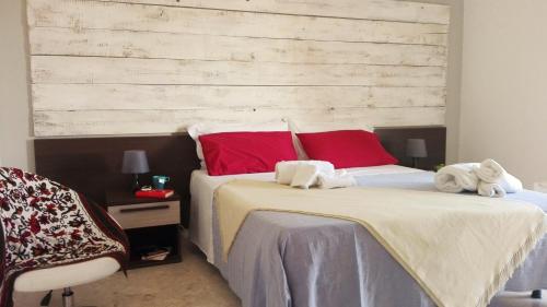 1 dormitorio con 2 camas y almohadas rojas y blancas en Sopra Isola, en Ioppolo Giancaxio