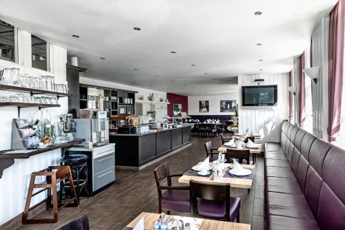 a restaurant with tables and chairs and a kitchen at Hotel Monopol in Gelsenkirchen