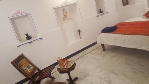 a bedroom with a bed and a chair and a mirror at Hari Niwas Guest House in Udaipur