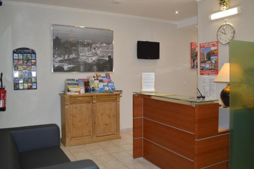 a waiting room with a counter and a clock on the wall at Backpackers Chez Patrick in Nice