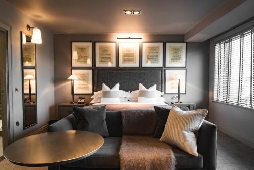 a bedroom with a bed with a couch and a table at Dakota Leeds in Leeds