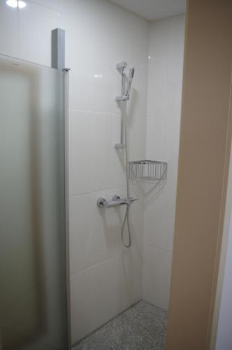 a shower in a white walled bathroom with at Casinha da Calçada in Ponte de Lima