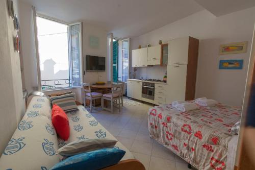 una camera con due letti e una cucina con tavolo di Appartamento Buranco a Monterosso al Mare