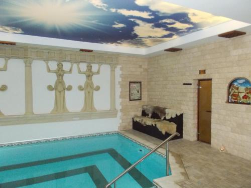 a swimming pool with a mural on the ceiling at Panorama Family Hotel in Zlatograd