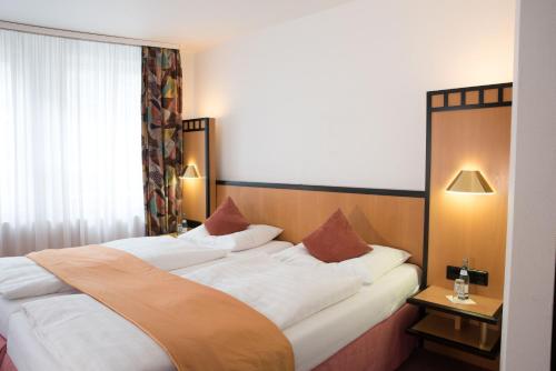 a hotel room with a bed and two lamps at Hotel Schere in Northeim
