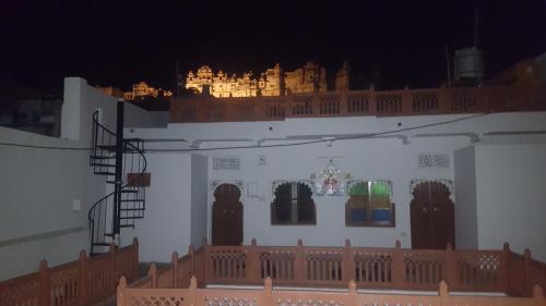 a white building with a balcony with lights on it at Hari Niwas Guest House in Udaipur