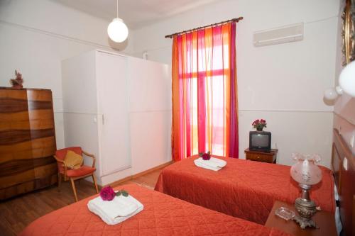 a hotel room with two beds and a television at Hotel Acropolis in Kavala