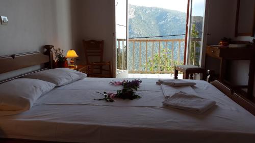 ein Schlafzimmer mit einem Bett mit Blumenarrangement darauf in der Unterkunft Epic Rooms in Delphi