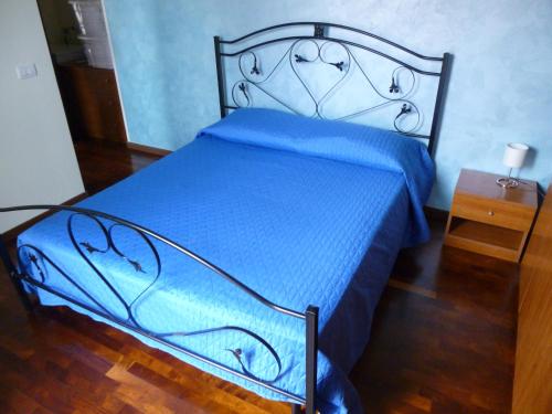 a bed in a room with a blue comforter at La Cornice del Garda in Cavalcaselle