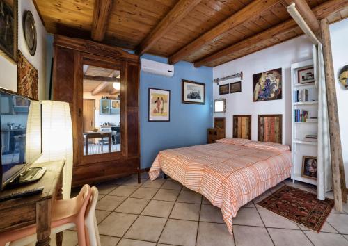 a bedroom with blue walls and a bed and a desk at Le Terrazze di Angela in Marina di Ragusa