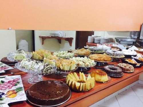 Pasto da MataHotel Santana - Posto da Mata BA的一张桌子,上面放着许多不同类型的蛋糕和糕点