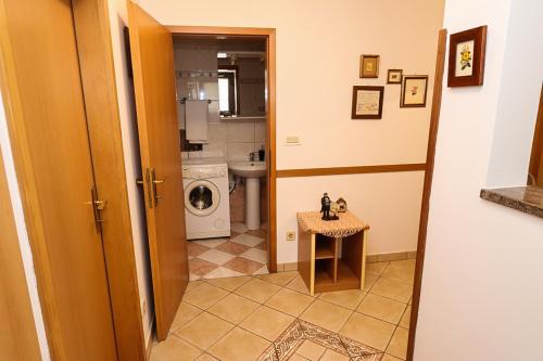 uma casa de banho com máquina de lavar e secar roupa num quarto em Altstadt em Lovran
