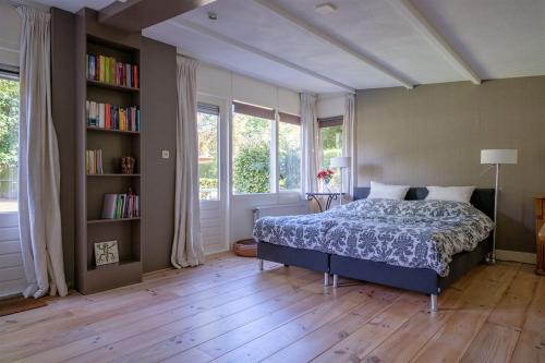 een slaapkamer met een bed en een boekenplank bij Bed and Breakfast Hattem in Hattem