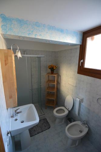 uma casa de banho com um lavatório, um WC e uma janela. em Ca' del Michelàs em San Pellegrino Terme