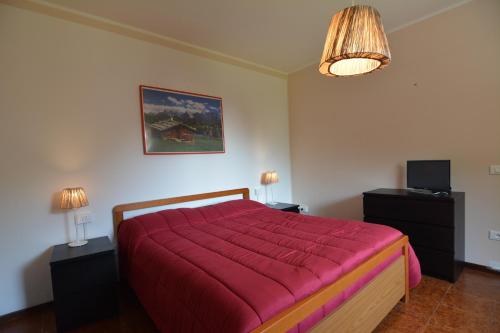 sypialnia z dużym łóżkiem i czerwonym kocem w obiekcie Ca' del Michelàs w mieście San Pellegrino Terme