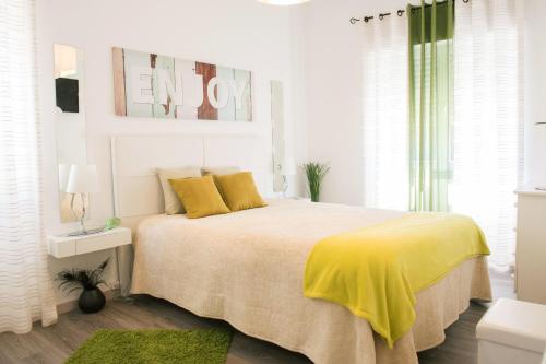 ein Schlafzimmer mit einem Bett mit gelber Bettwäsche und einer gelben Decke in der Unterkunft Vivenda Remos in Sesimbra