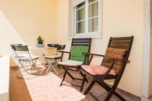 a group of chairs sitting next to a wall at Vivenda Remos in Sesimbra