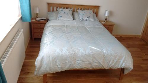 a bed with a white comforter in a bedroom at Fara 2 room, 1 bedroom - B&B private suite in Kirkwall