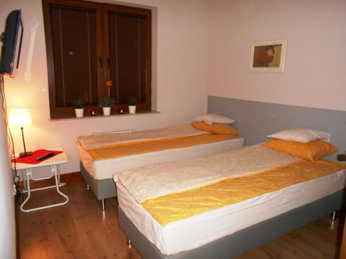 2 łóżka w małym pokoju z oknem w obiekcie Apartament Józefa w Toruniu