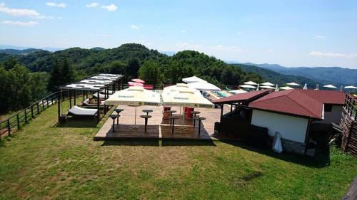 a group of tables and umbrellas on a field at Panorama Family Hotel in Zlatograd