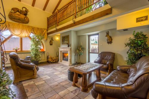 a living room with leather furniture and a fireplace at Pensjonat Carmen in Szklarska Poręba