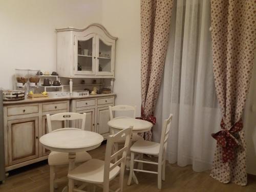 福賈的住宿－B&B LEI，厨房配有2张桌子和椅子以及水槽