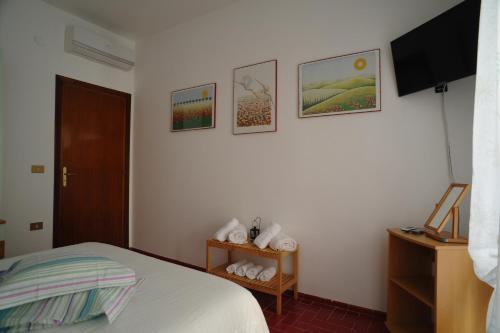 a bedroom with a bed and some pictures on the wall at Daniela House in Maiori