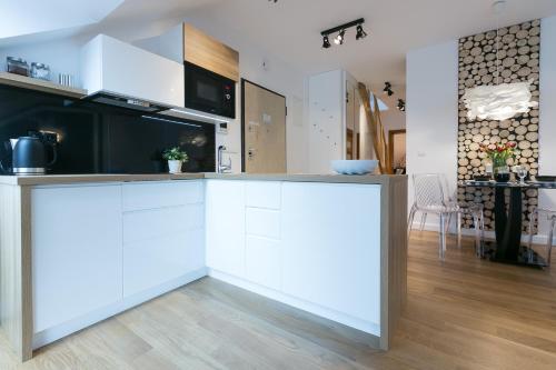 a kitchen with white cabinets and a counter top at VIP Apartamenty Stara Polana in Zakopane