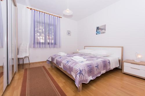 - une chambre blanche avec un lit et une fenêtre dans l'établissement Apartment Tina, à Trogir
