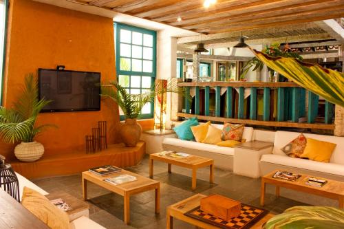 a living room with a couch and a tv in it at Ilha Deck Hotel in Ilhabela