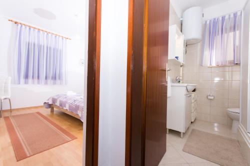 La salle de bains est pourvue d'un lavabo et de toilettes. dans l'établissement Apartment Tina, à Trogir