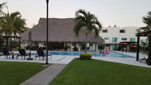 a resort with a swimming pool with palm trees and a building at Casa Diamante en Zona Diamante in Acapulco