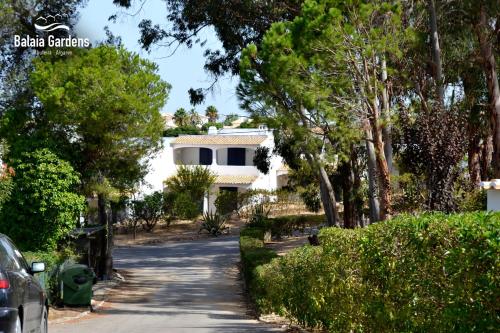 a house in the middle of a road with trees at Balaia Gardens, jardins da Balaia in Albufeira