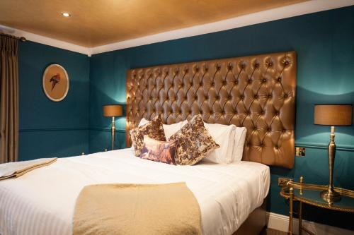 um quarto com uma cama grande e uma cabeceira de couro em The Rooms at Bardons em Kilcullen
