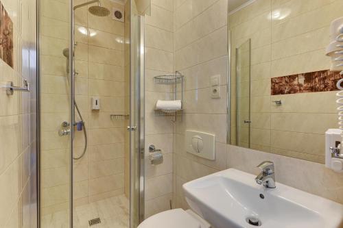 een badkamer met een douche, een wastafel en een toilet bij Abak in Gdańsk