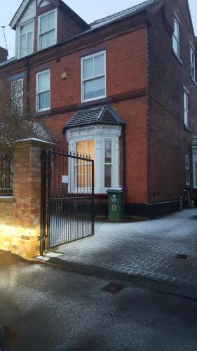 a brick house with a gate in front of it at Haya Guest House in Birmingham