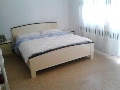 a white bed in a bedroom with a window at Residence Rotonda in Savignano sul Rubicone
