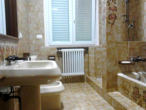 La salle de bains est pourvue d'un lavabo, de toilettes et d'une baignoire. dans l'établissement Residence Rotonda, à Savignano sul Rubicone